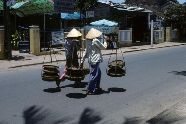 <img typeof="foaf:Image" src="http://statelibrarync.org/learnnc/sites/default/files/images/vietnam_107.jpg" width="600" height="400" alt="Two women carry trays suspended from shoulder poles, Hoi An" title="Two women carry trays suspended from shoulder poles, Hoi An" />