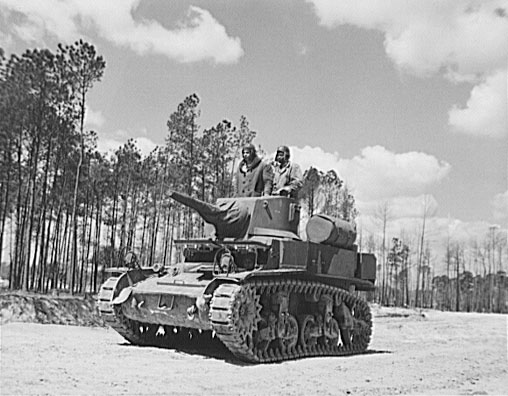 Marines escort an anti-aircraft gun. Black and white photo.